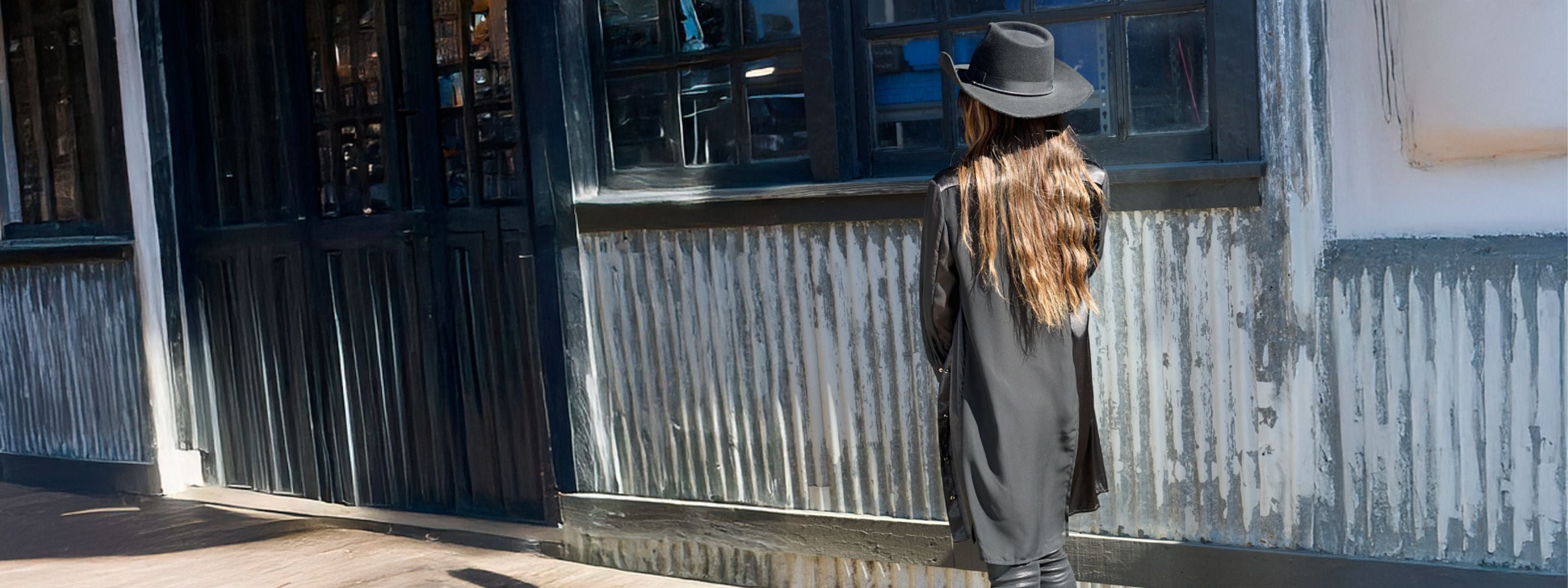 woman wearing a black aliferous shirtdress by inlarkin in front of a store front background