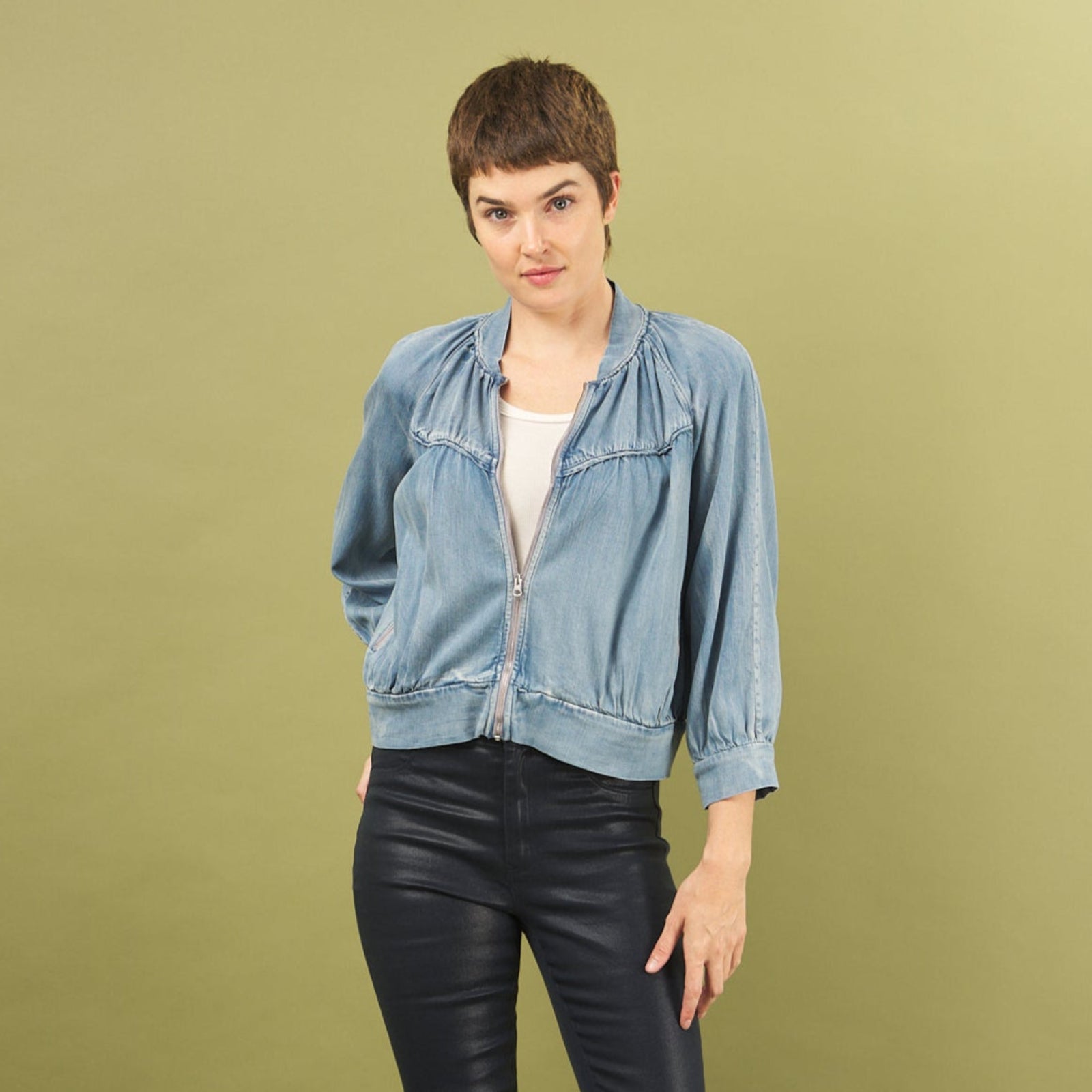 Woman wearing a denim boy bomber jacket by inlarkin on a green background