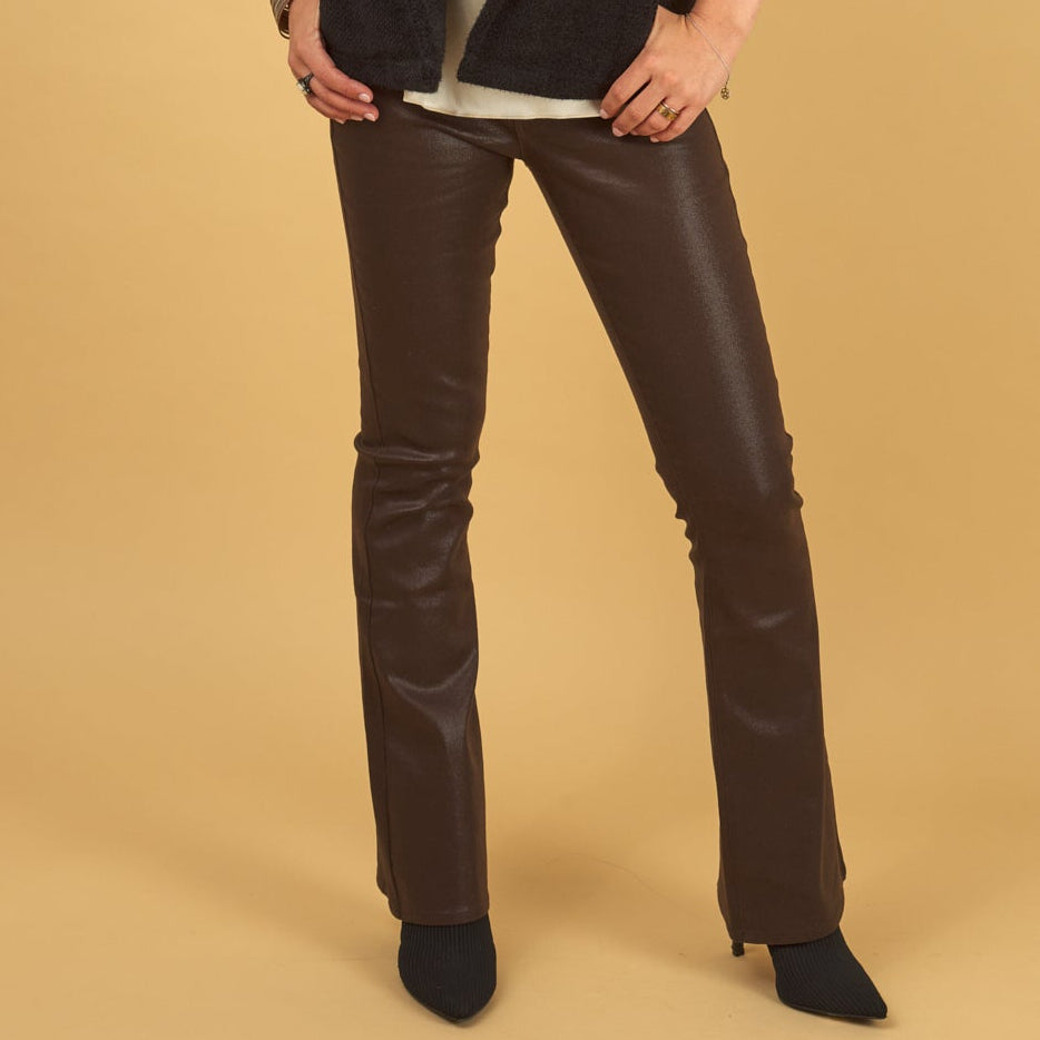 chocloate gloss curve jean by inlarkin with black boots on a yellow background
