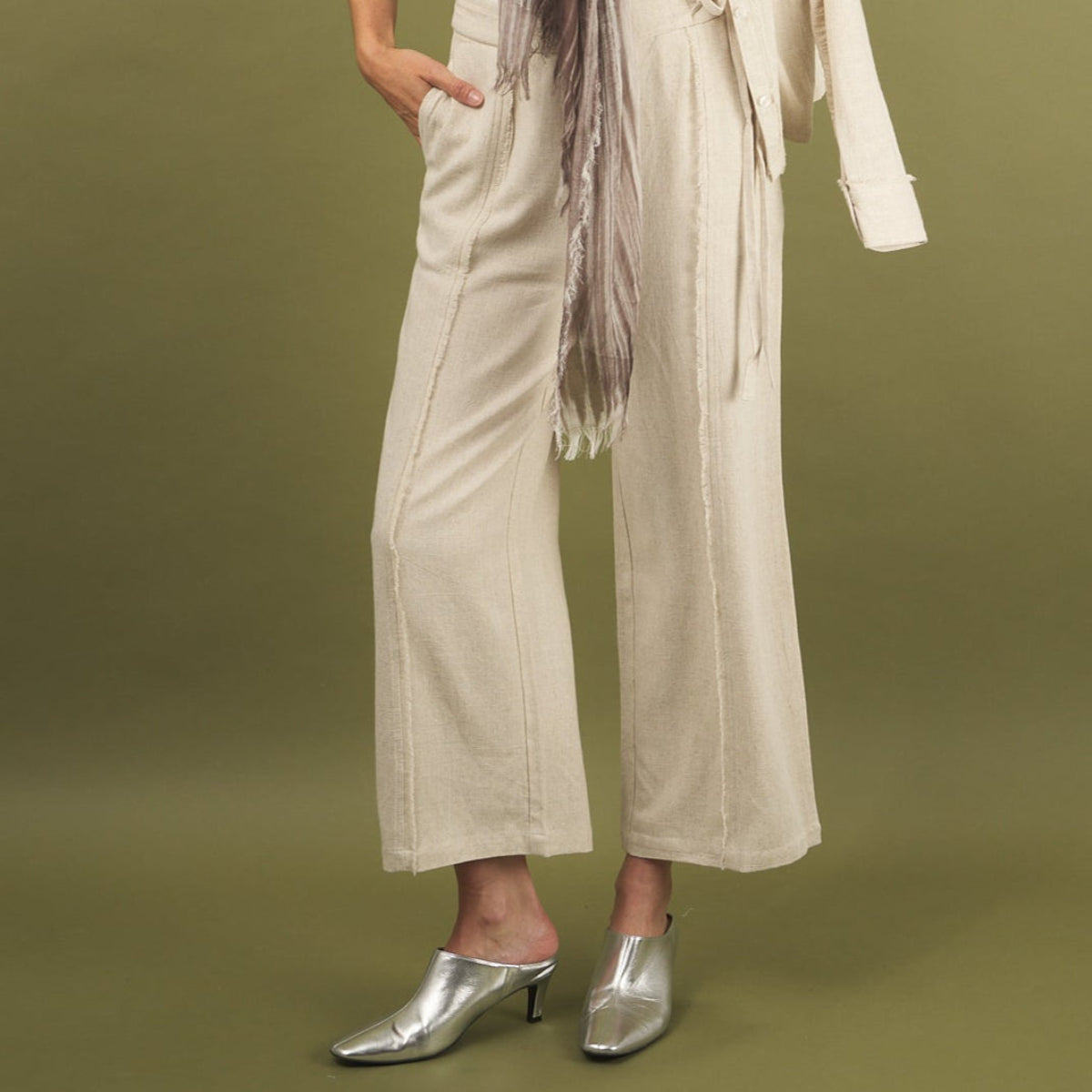 the linen fray pant in sand front view with frayed seams, front waistband tie and pockets
