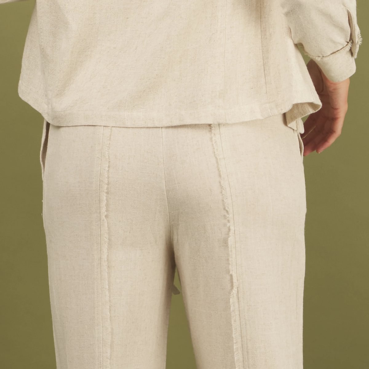 the linen fray pant in sand back view detail with frayed seams and pockets