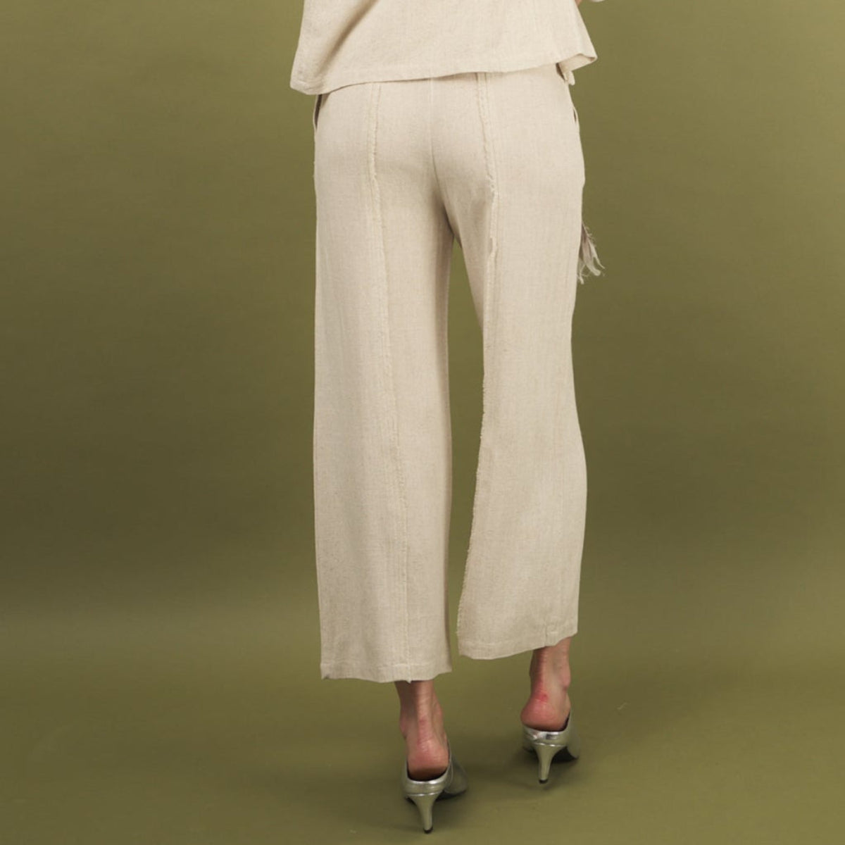 the linen fray pant in sand back view with frayed seams, and cropped length