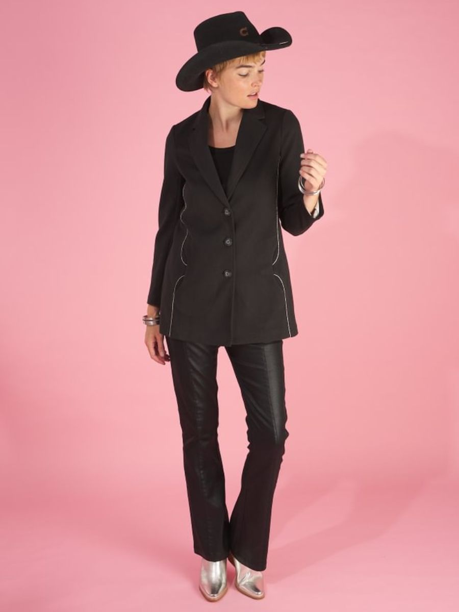 Woman wearing a black maxine blazer by inlarkin and cowboy hat on a pink background
