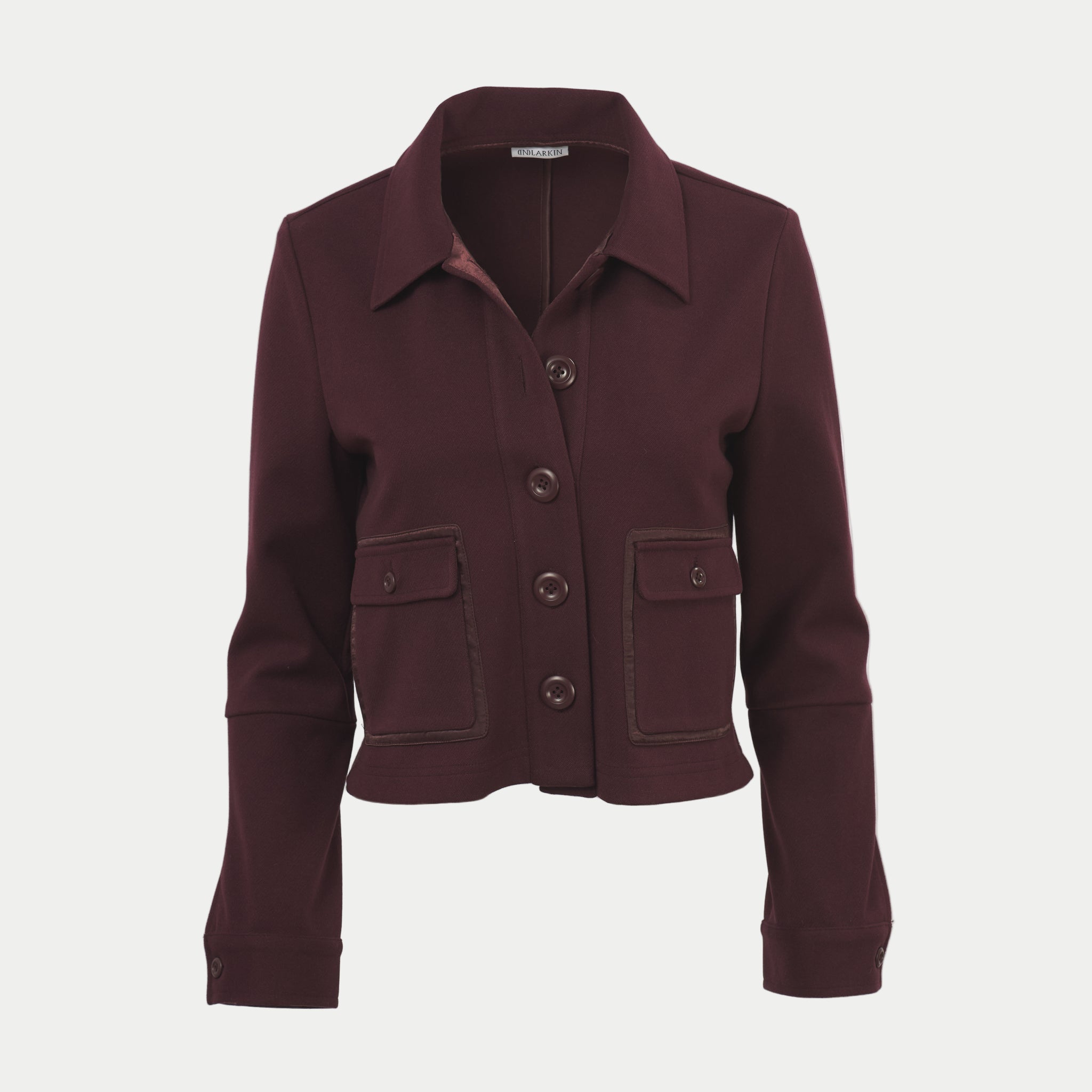 Damson colored shaket crop jacket by inlarkin with button details on an off-white background