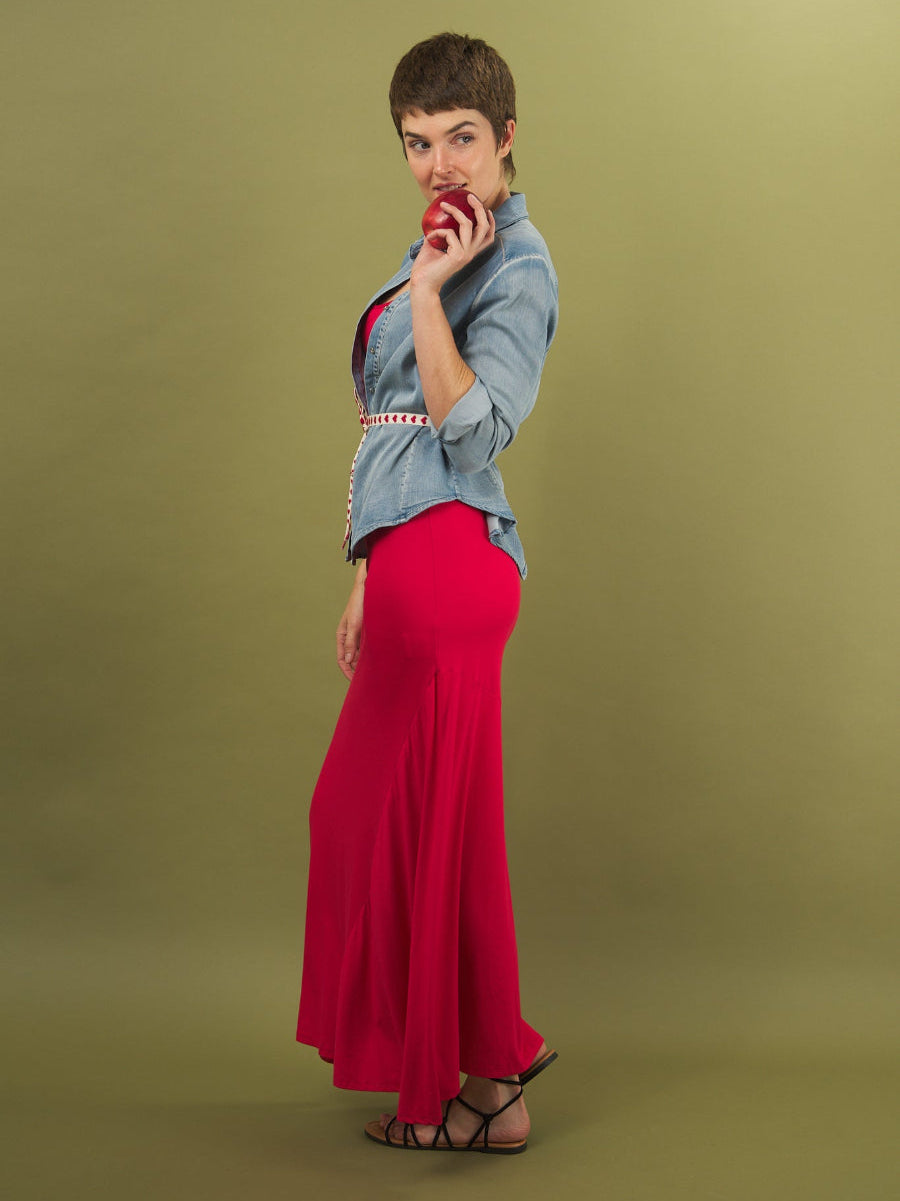 Woman wearing a denim alex shirt and red sharyn dress by inlarkin against a green background