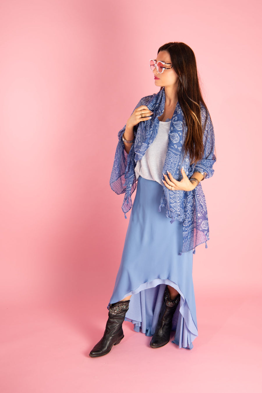 Woman wearing a blue shay skirt by inlarkin with a lace shawl against a pink background