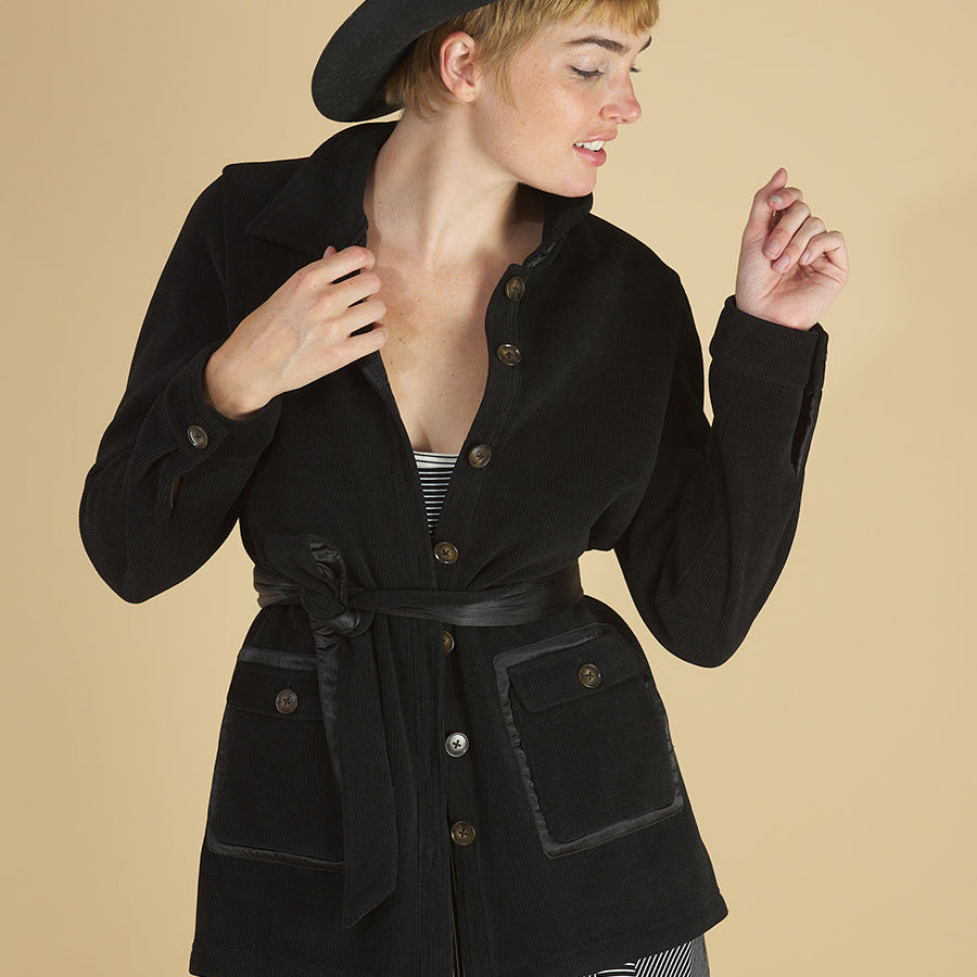 shirt jacket by inlarkin in black front view detail featuring the front sateen patch pockets and sea glass buttons