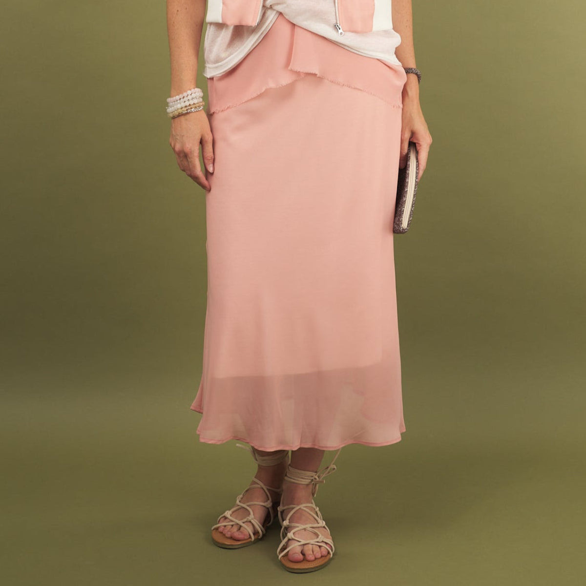 a coral midi length slay skirt by inlarkin front view with a sheer layer at the hem and side pockets
