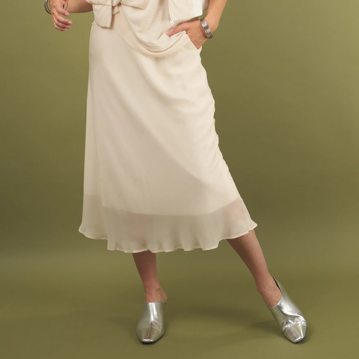 a cream midi length slay skirt by inlarkin front view with a sheer layer at the hem and side pockets