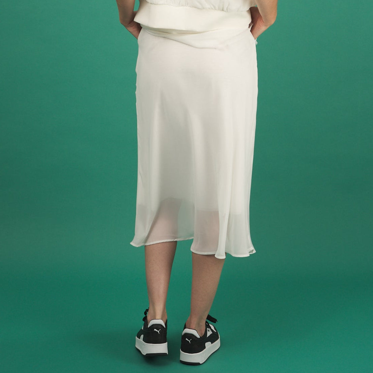 a white midi length slay skirt by inlarkin back view with a sheer layer at the hem and side pockets