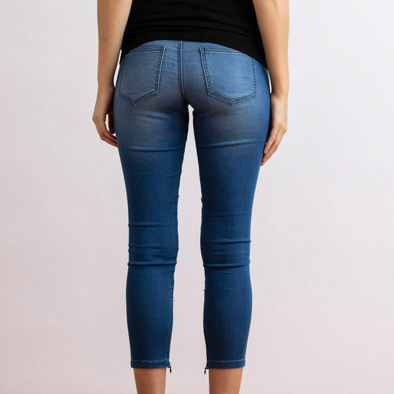 back view of model in the unreal jean by inlarkin showing the slimming fit with back pocket and zipper detail at the ankles