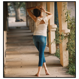  Model from behind wearing a butterfly inspired tank top with jeans