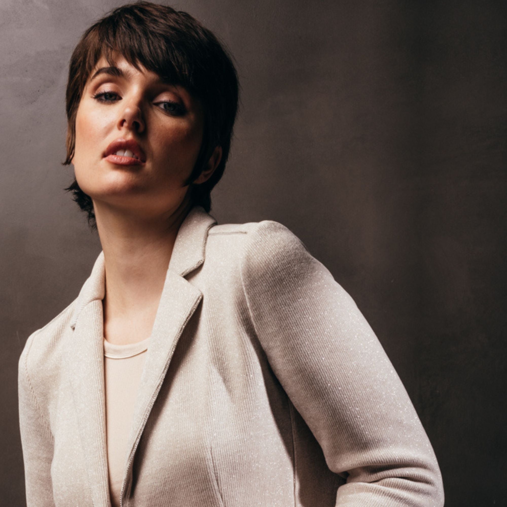 image of a woman wearing the michele blazer by inlarkin showing the sparkly shimmer of the fabric
