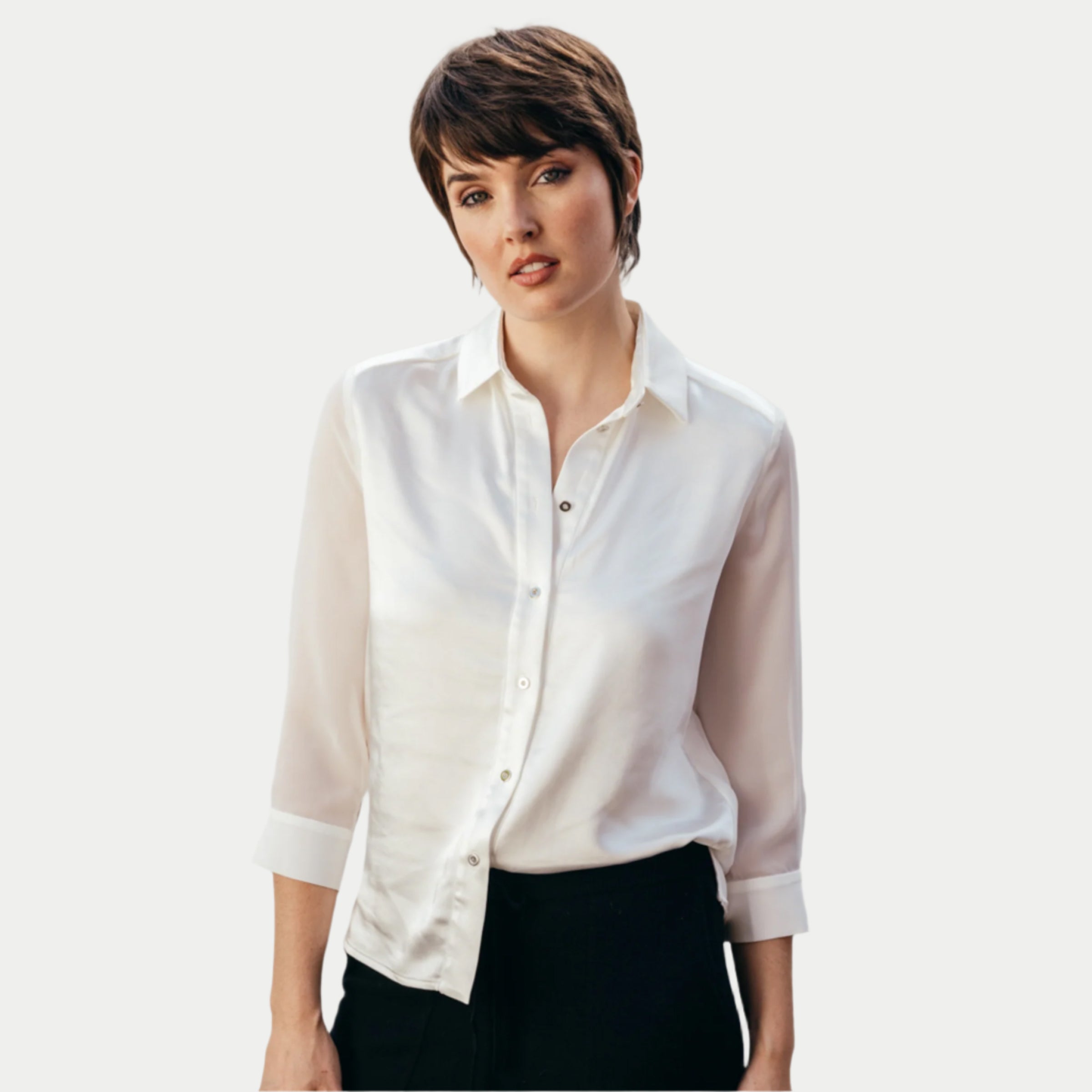 woman standing wearing a white buttoned up aliferous shirt by inlarkin showing the button detail, bracelet sleeve length and sheer sleeve detail