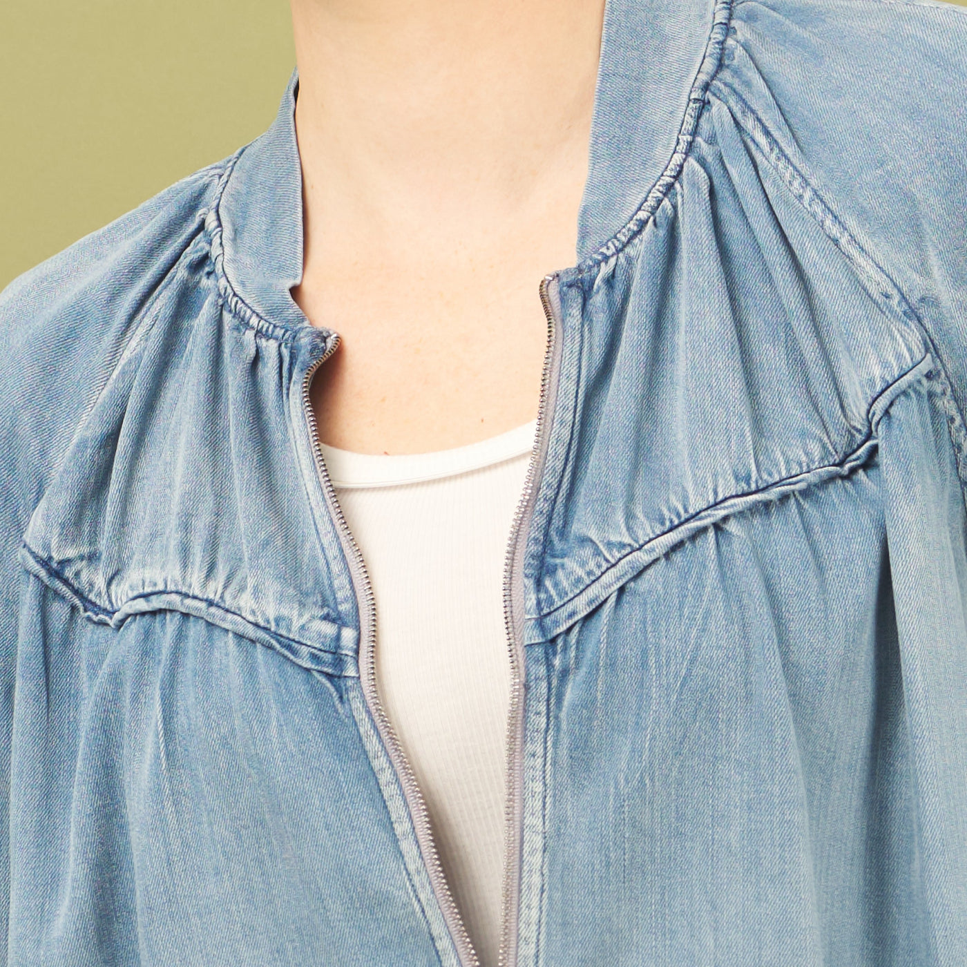 Light blue denim jacket worn by a person on a plain background