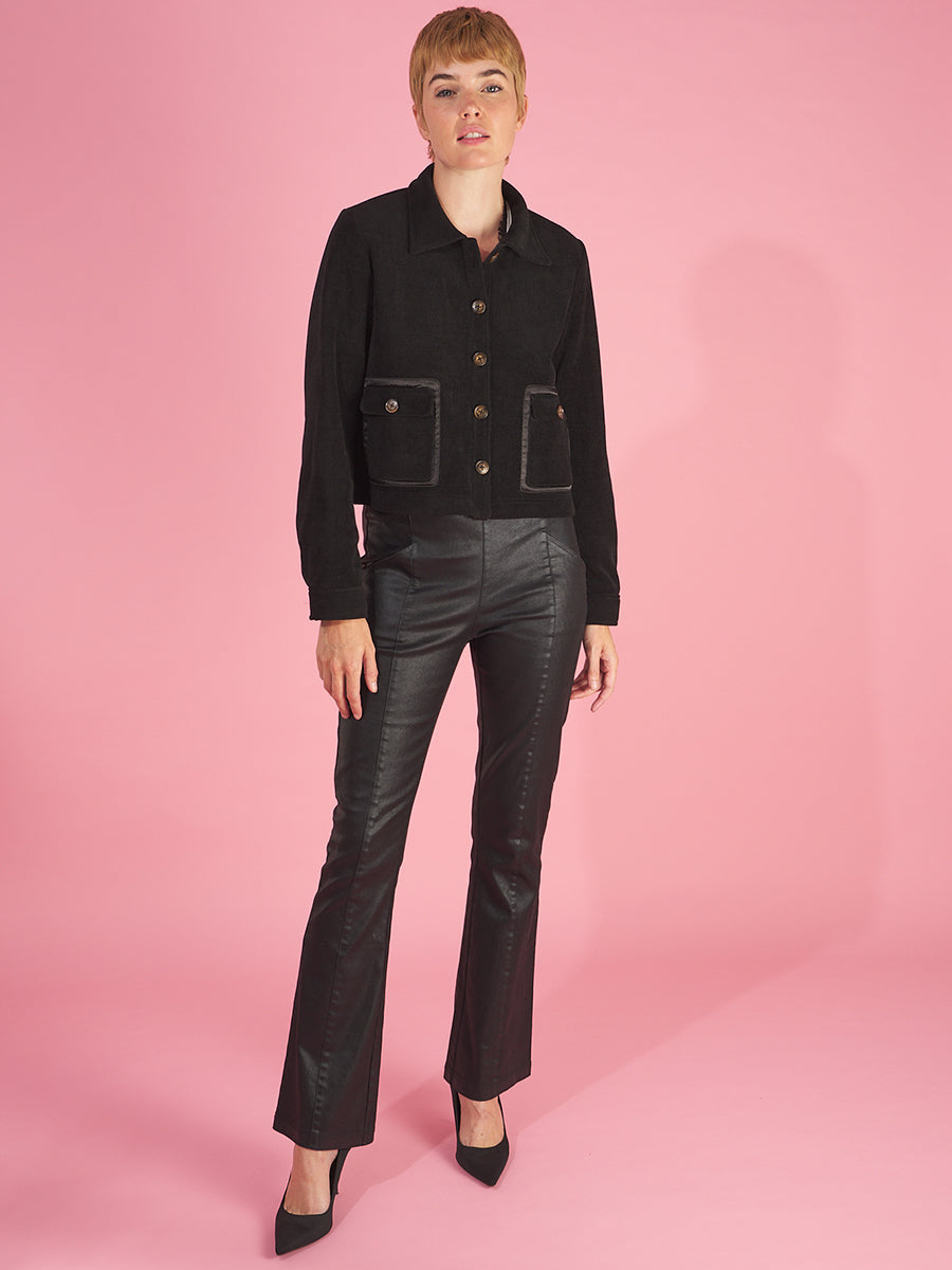 the cropped shirt jacket by inlarkin in black front view featuring the sea glass buttons, front patch pockets and collar paired with the sublime gloss jean in black with front pockets and front seaming