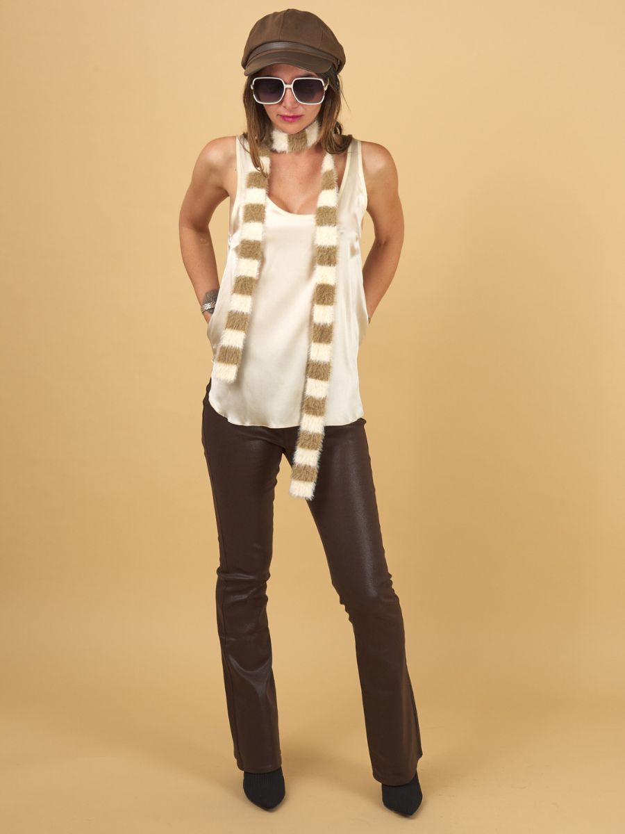 a woman wearing an ecru decuir silk shell by inlarkin with chocolate gloss curve jeans on a yellow background