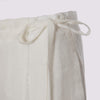 detail view of the duster pant in white by inlarkin showing the tie waistband , zipper and top of pocket