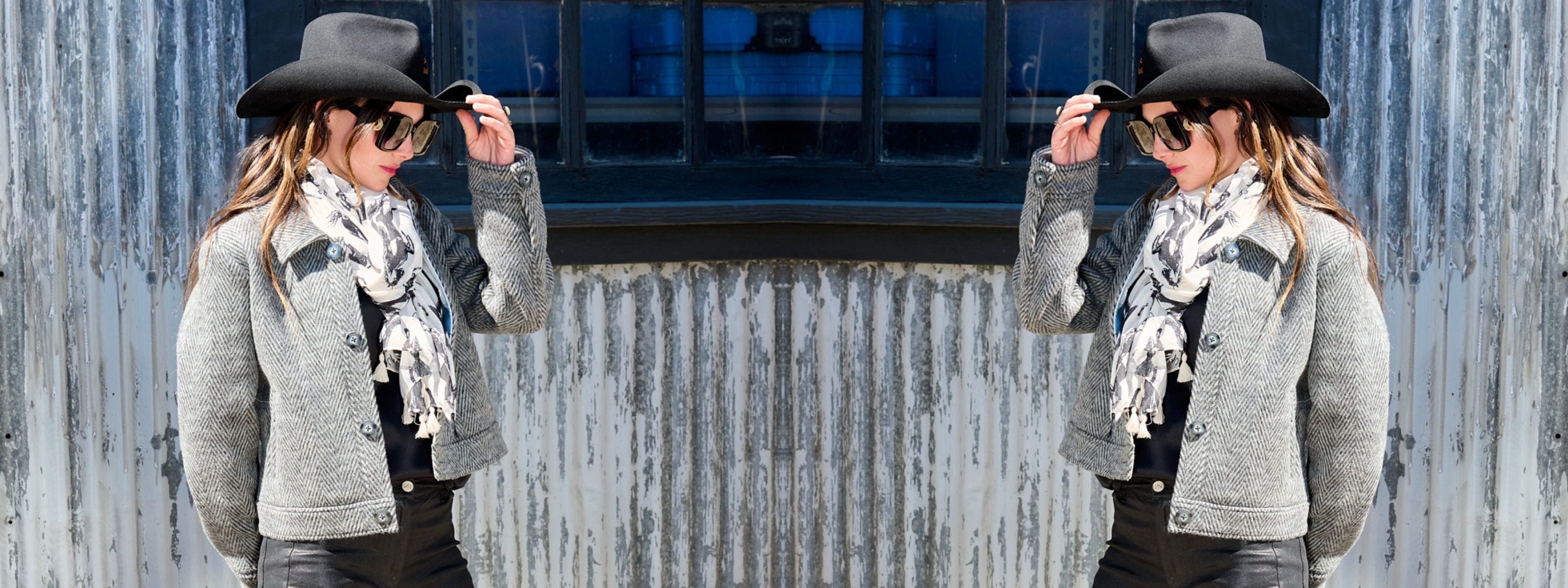 two women wearing harriet herringbone jackets by inlarkin, black hats, and patterned scarves against a textured wall.