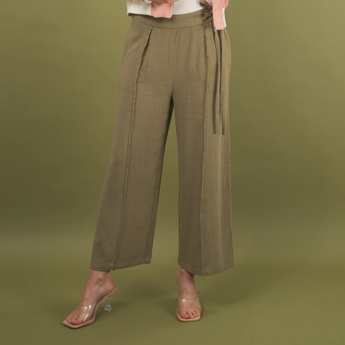 the linen fray pant in sage green front view with frayed seams, front waistband tie and pockets