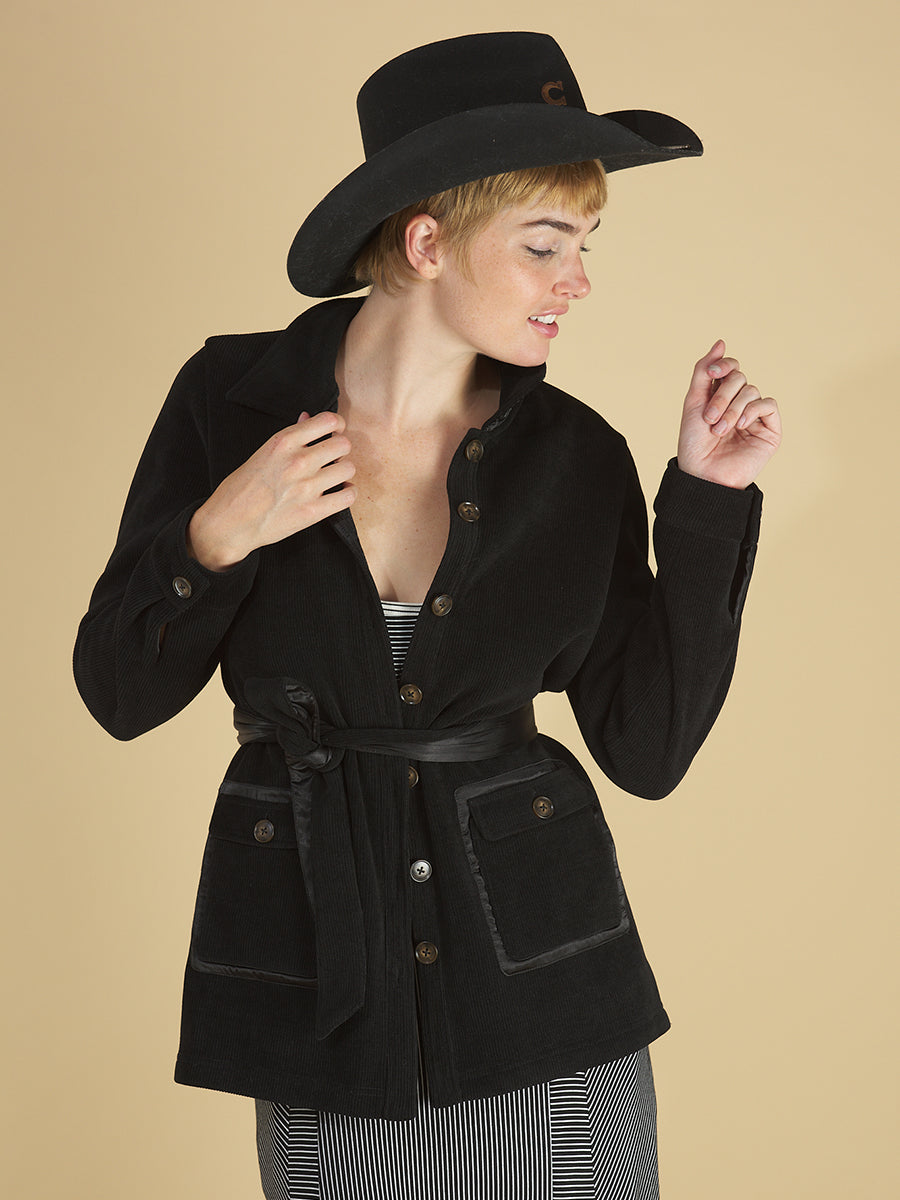 shirt jacket by inlarkin in black front view detail featuring the front sateen patch pockets and sea glass buttons