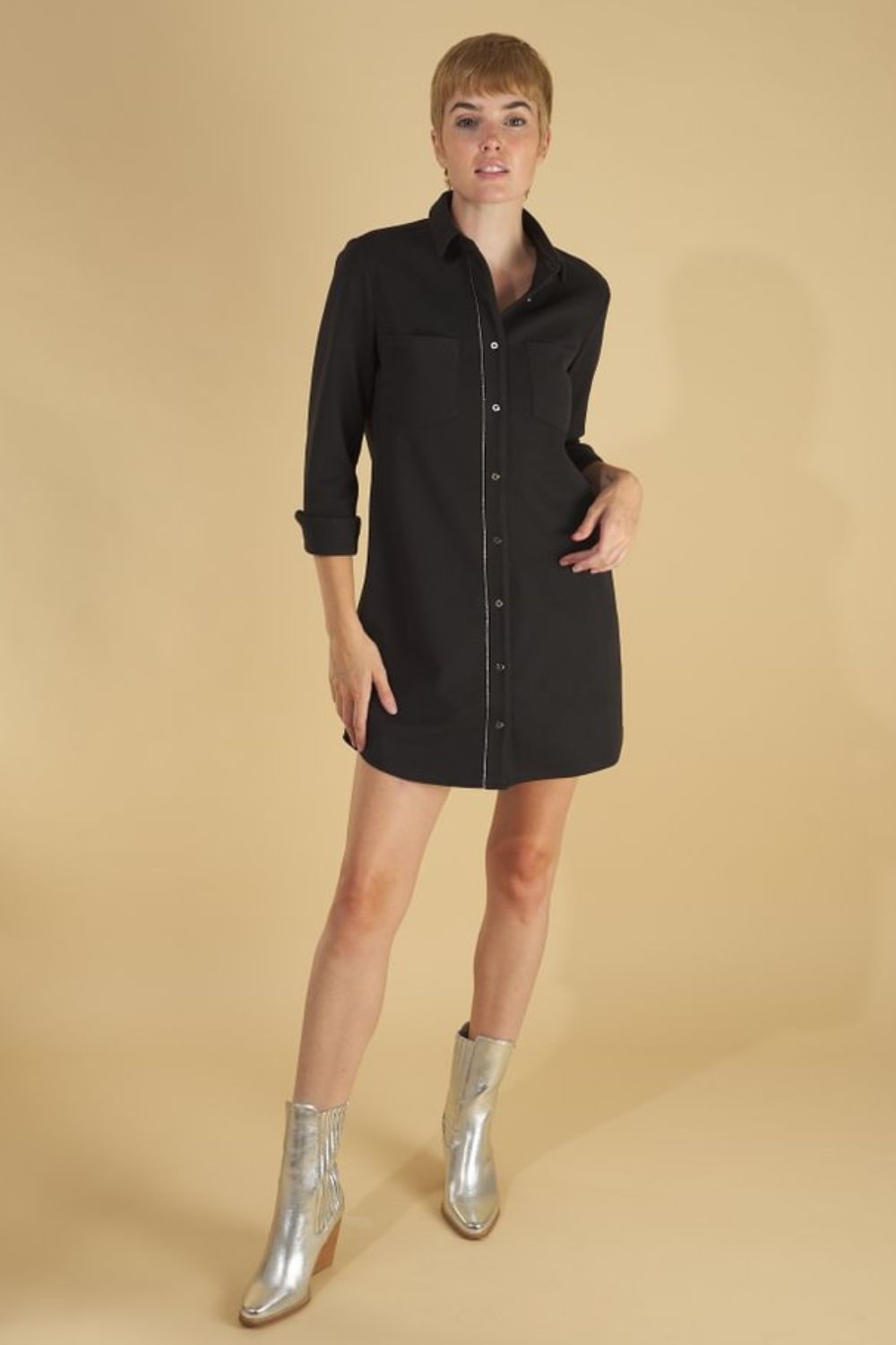 the sy shirtdress by inlarkin in black front view worn as a dress with length at mid thigh an showing the long sleeves cuffed, silver trim and buttons