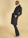 the toni trench coat by inlarkin in black side full view showing the high gloss fabric, side seam pocket and belt