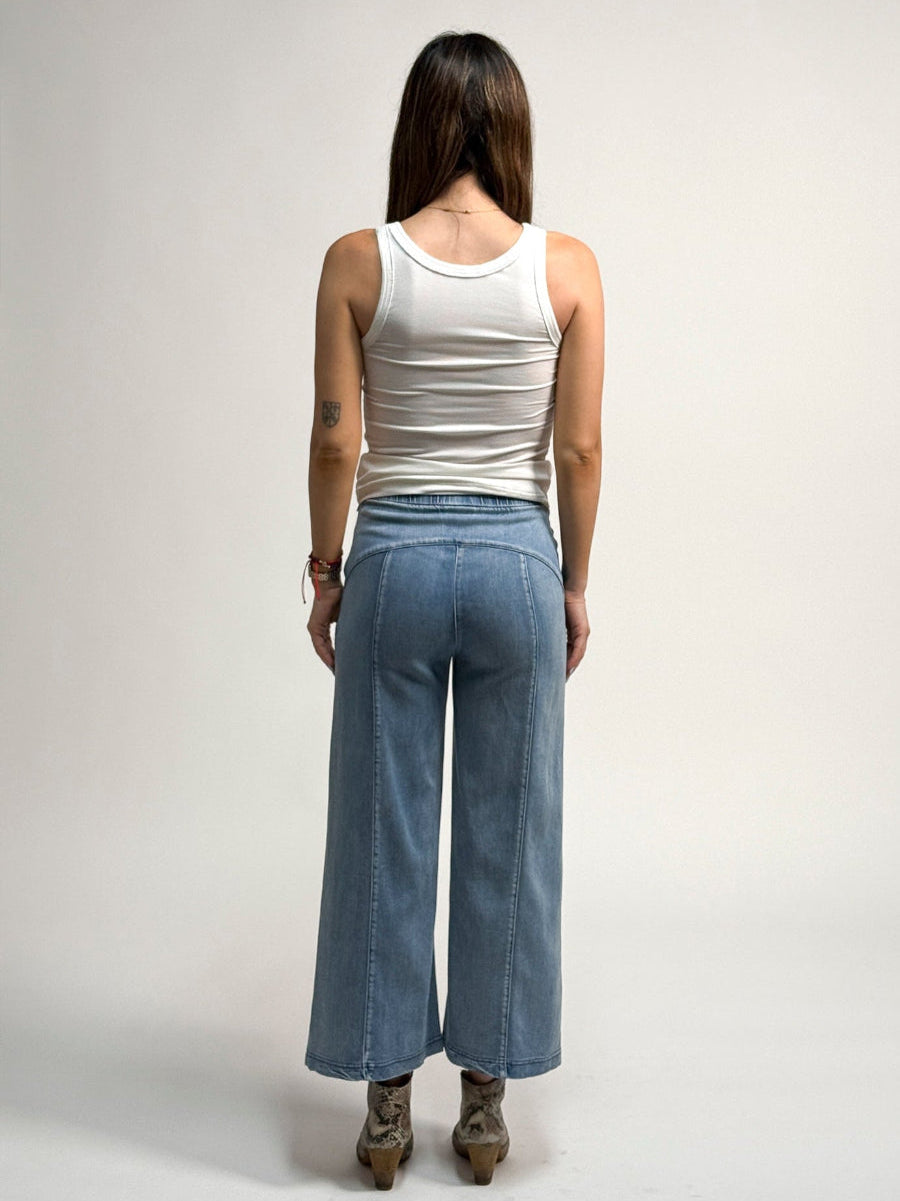 Person wearing a white tank top and denim whitley jeans by inlarkin on a plain background
