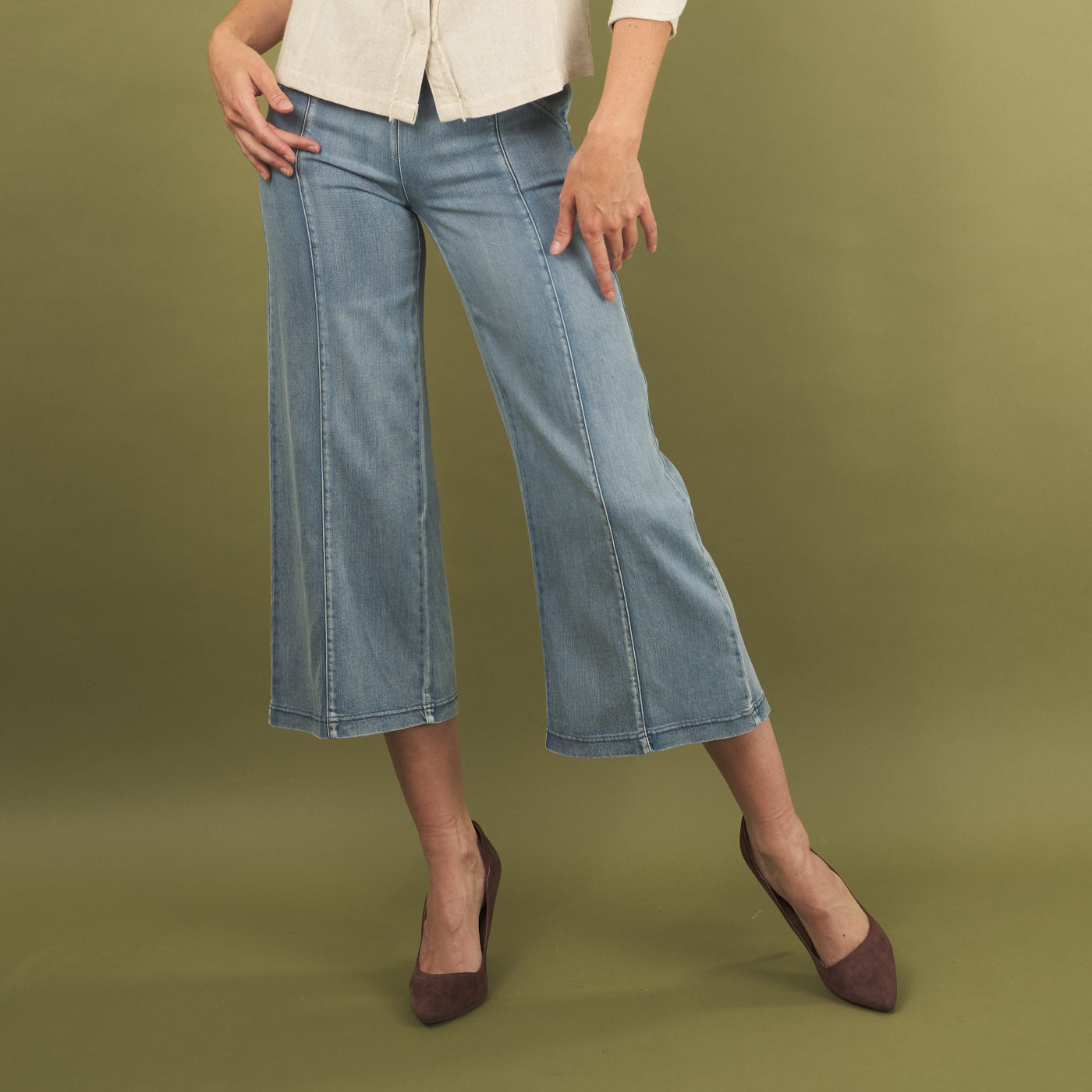 woman wearing the whitley jean by inlarkin and brown shoes on a green background