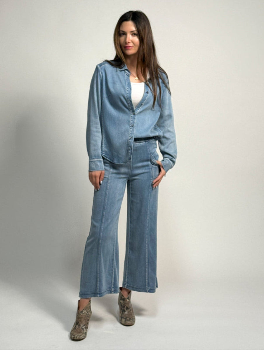 Woman wearing denim whitley pants and the alex denim shirt by inlarkin on a plain backgroung
