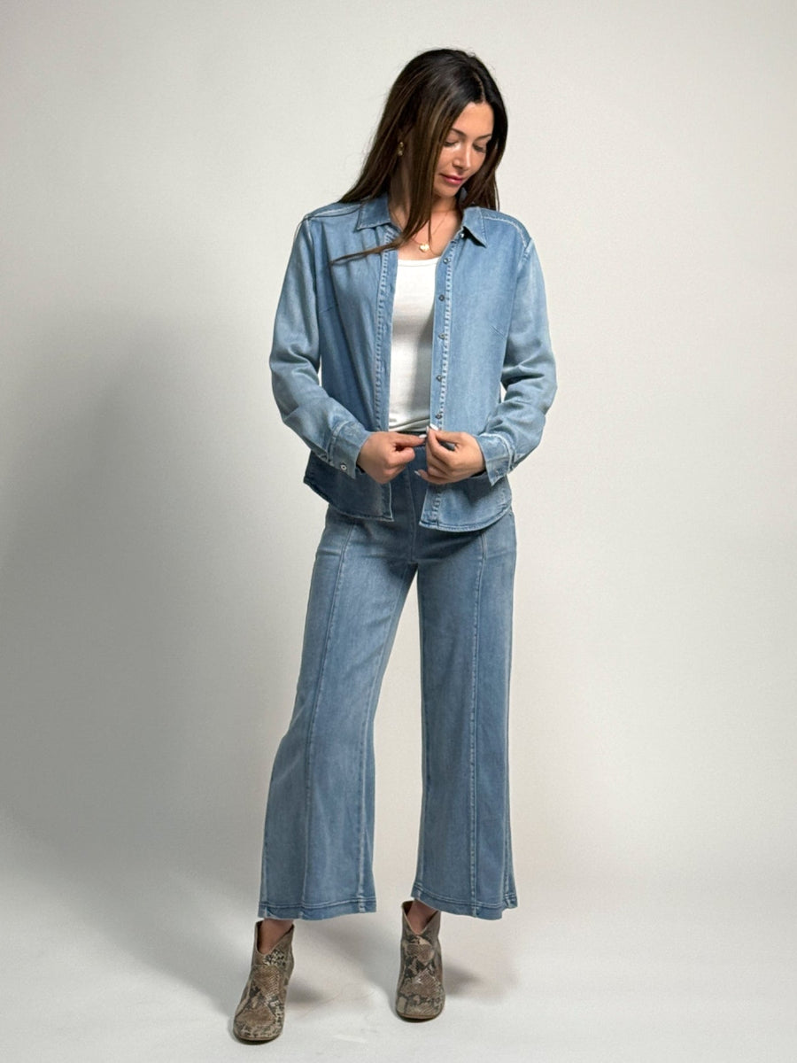 Woman wearing a denim alex shirt and whitley jeans by inlarkin on a plain background