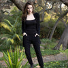 woman standing on a rock in a lush garden wearing black cashmere blend joggers and a black cashmere cardigan by inlarkin