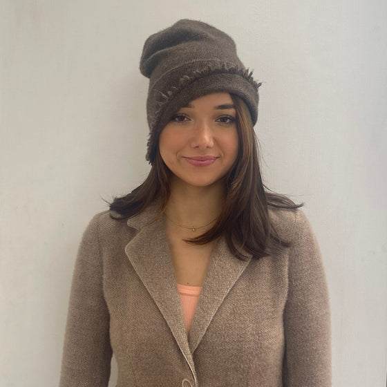 woman wearing the cashmere beanie in brown showing the frayed edge and versatility of the beanie