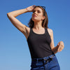 woman standing outdoors with a black variegated tank top with satin detail neckline and arm holes by inlarkin